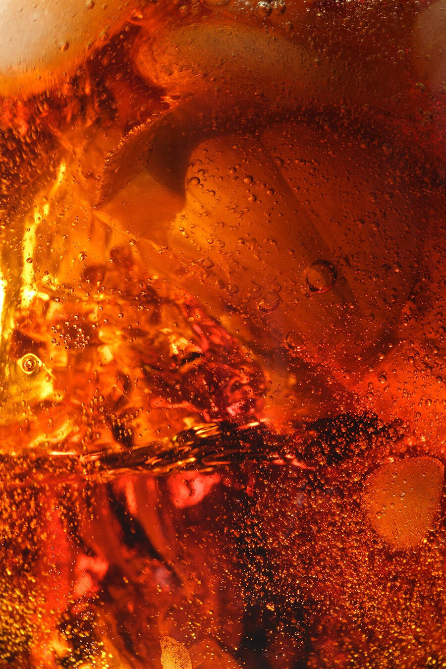 Macro detailed shot a glass filled with fizzy beverage with lemons and ice